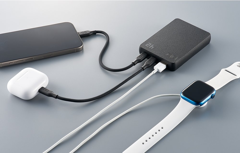 SMARTCOBY Pro SLIM SSに3本のケーブルをつなぎ、スマートフォン、ワイヤレスイヤホンのケース、腕時計を同時に充電している写真。