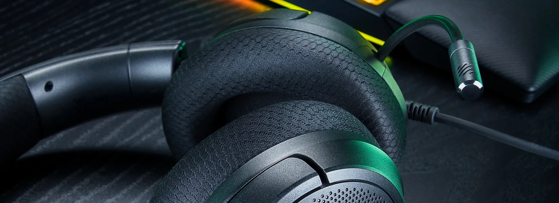 Razer Kraken V4 X Sensa HD Hapticsのイヤーカップを斜めから寄って撮った写真。黒い布地のメモリーフォームクッションと、緑色の差し色が入ったカップの縁が写っている。